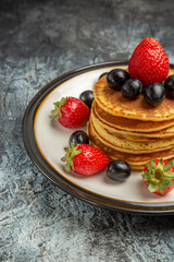 front view delicious pancakes with fruits and berries on dark floor cake fruit dessert