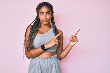 Young african american woman with braids wearing sports clothes skeptic and nervous, frowning upset because of problem. negative person.