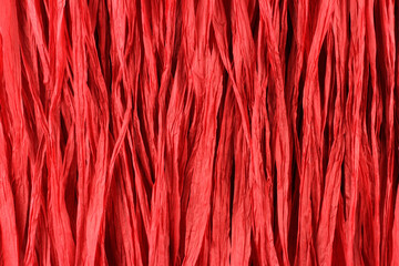 Background - red paper raffia strips situated in parallel lines.