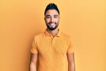 Obraz premium Young man with beard wearing casual clothes with a happy and cool smile on face. lucky person.