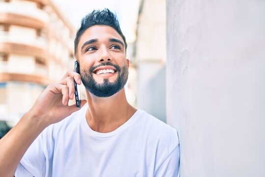 Young arab man with serious expression talking on the smartphone at the city.