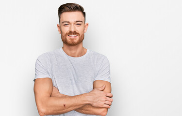 Obraz premium Young redhead man wearing casual grey t shirt happy face smiling with crossed arms looking at the camera. positive person.