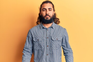 Young arab man wearing casual clothes with serious expression on face. simple and natural looking at the camera.