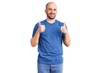 Young handsome man wearing casual t shirt success sign doing positive gesture with hand, thumbs up smiling and happy. cheerful expression and winner gesture.
