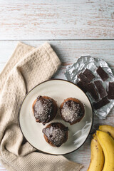 Top view flat lay on chocolate muffin cakes with banana on the table