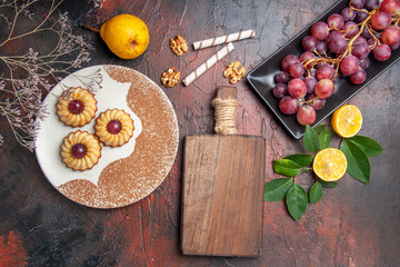 top view yummy little cookies with grapes on dark floor cake sweet biscuit sugar