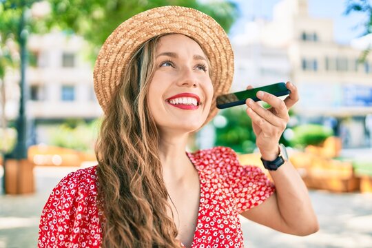 Young blonde woman on vacation smiling happy talking on the smartphone at street of city