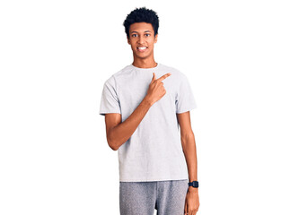 Fototapeta premium Young african american man wearing casual clothes cheerful with a smile of face pointing with hand and finger up to the side with happy and natural expression on face