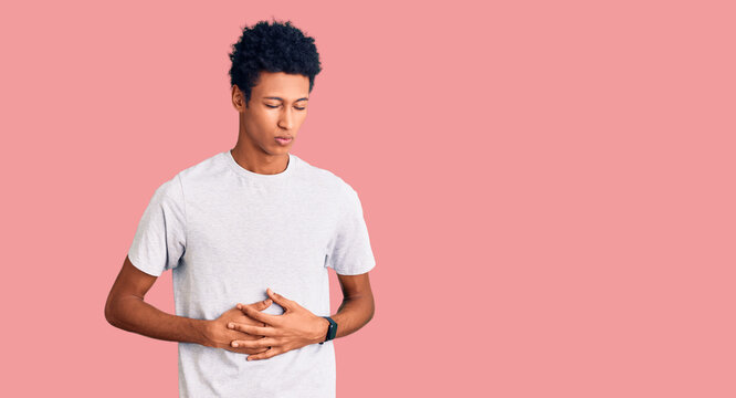 Young african american man wearing casual clothes with hand on stomach because indigestion, painful illness feeling unwell. ache concept.