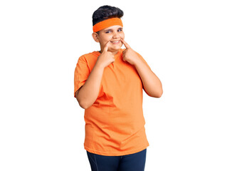Little boy kid wearing sportswear smiling with open mouth, fingers pointing and forcing cheerful smile