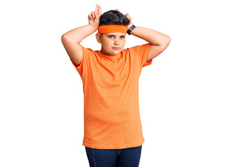 Little boy kid wearing sportswear doing bunny ears gesture with hands palms looking cynical and skeptical. easter rabbit concept.