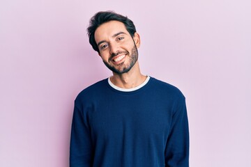 Fototapeta premium Young hispanic man wearing casual clothes with a happy and cool smile on face. lucky person.