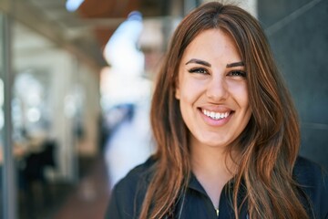 Fototapeta premium Young hispanic woman smiling happy walking at street of city