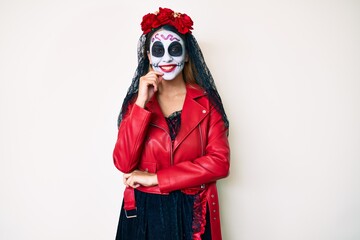 Woman wearing day of the dead costume over white looking confident at the camera smiling with crossed arms and hand raised on chin. thinking positive.