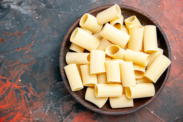 Close up view of uncooked pastas inside the pot on black background