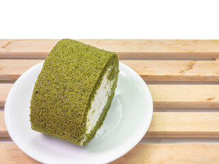 The close up of homemade matcha green tea cream roll soft cake dessert food with wood plank on white background.