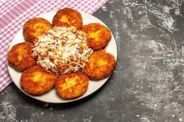 top view fried cutlets with cooked rice on the dark background meat dish rissole