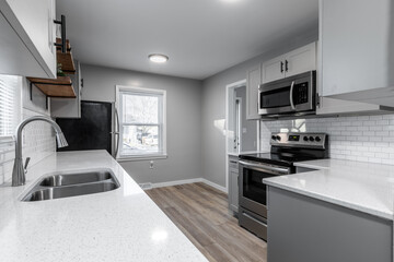 Kitchen with gray cabinets, white subway tile backsplash and wood accents 