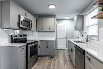 Kitchen with gray cabinets, white subway tile backsplash and wood accents 