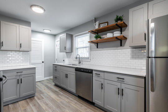 Kitchen with gray cabinets, white subway tile backsplash and wood accents 