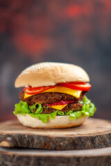 front view meat burger with salad cheese and tomatoes on a dark background bun sandwich fast-food