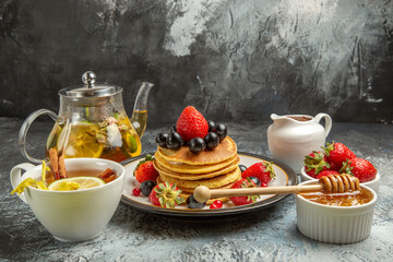 front view yummy pancakes with fruits and tea on light background sweet fruits breakfast