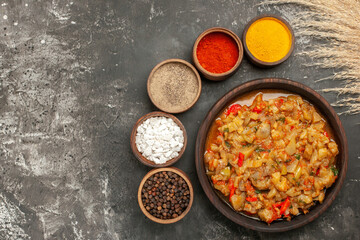 top view roasted eggplant salad in bowl different spices on dark background free space
