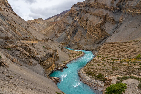 Meander is one of a series of regular sinuous curves in a river, produced by river as it erodes the sediments from outer concave cut bank and deposits sediment downstream on an inner convex bank.