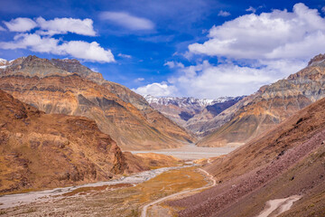 Fototapeta na wymiar Beautiful view of cold desert arid landscape enroute off road connecting Kaza town with Chandratal Lake passing through Kunnzum Pass in Lahaul Spiti region of Himalayas in Himachal Pradesh, India.