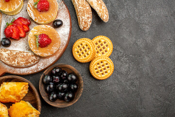 top view tasty pancakes with different sweets on dark floor sugar cake dessert