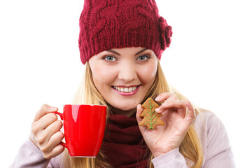 Woman in cap and shawl holding gingerbread and cup of hot tea, christmas time