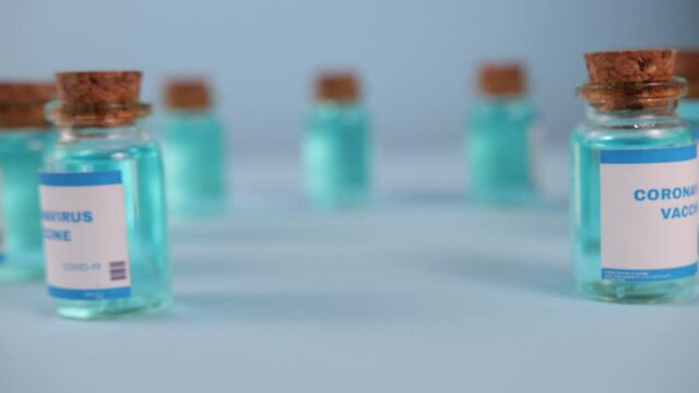 Close-up of gloved hand takes vial Coronavirus vaccine. Coronavirus COVID-19 scientist hands concept. Research for new novel corona virus immunization drug.