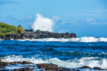 Fototapeta na wymiar Wave Splashing On Rocks at Punalu'u Black Sand Beach