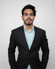 Asian Businessman in black suit looking into the camera while keeping hand in pocket.