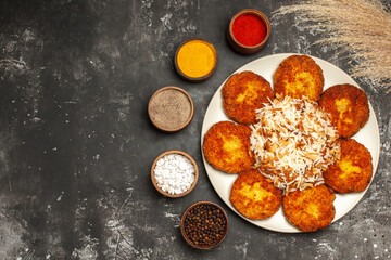 top view fried cutlets with cooked rice and seasonings on dark background dish photo meat