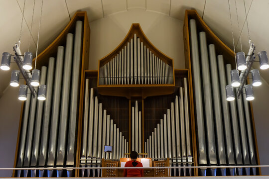 woman playing the organ on the balcony of the church