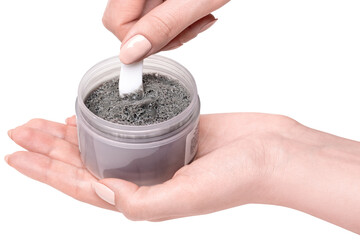 Korean charcoal bubble clay face mask in jar on female hands applied by spatula