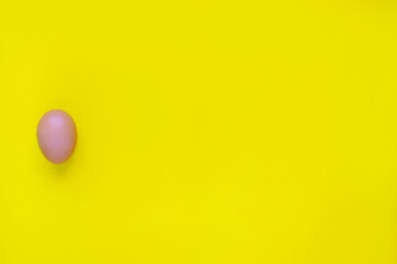 A brown fresh chicken egg was placed on a yellow background.