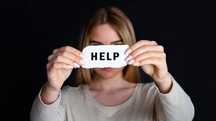 Call for help. Woman unrecognizable holding piece of paper with inscription