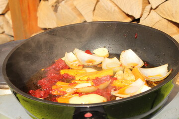 Onions and carrots are sautéed in a pan with tomato paste