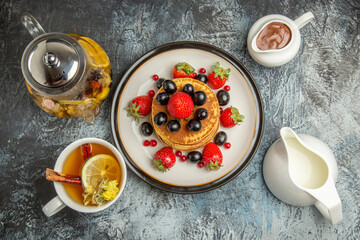 top view yummy pancakes with fruits and tea on a light background sweet fruits breakfast