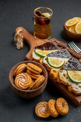 front view cake slices with chocolate and cookies on a dark background cake pie sweet dessert