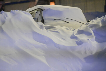 van car covered with deep cover of white snow drift snowbank at night winter vacation trip resort...