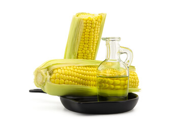 Corn oil in decanter and fresh corncobs
