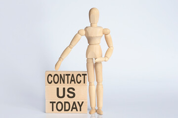 Wooden man shows with a hand text CONTACT US TODAY concept on the wooden block