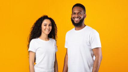 Multiethnic Couple Posing Standing Over Yellow Studio Background, Panorama - Powered by Adobe