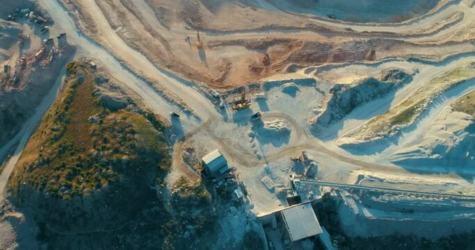 Aerial view of opencast mining quarry with lots of machinery at work - view from above. 