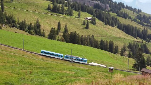 SLOW MOTION: Scenic landscape between Alps, valleys of Rigi Mountain railways and blue cog train. Rigi Kulm summit and railway. Canton of Schwyz and Lucerne, Central Switzerland.