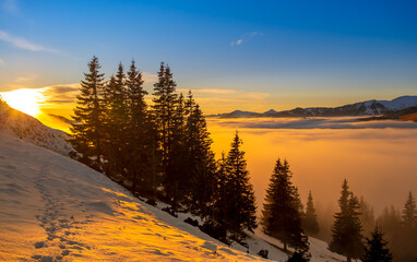 Beautiful sunset over sea of clouds. Winter landscape