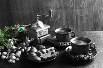 Two cups of coffee, coffee pot, coffee grinder, saucer with cookies and chocolates on wooden texture 